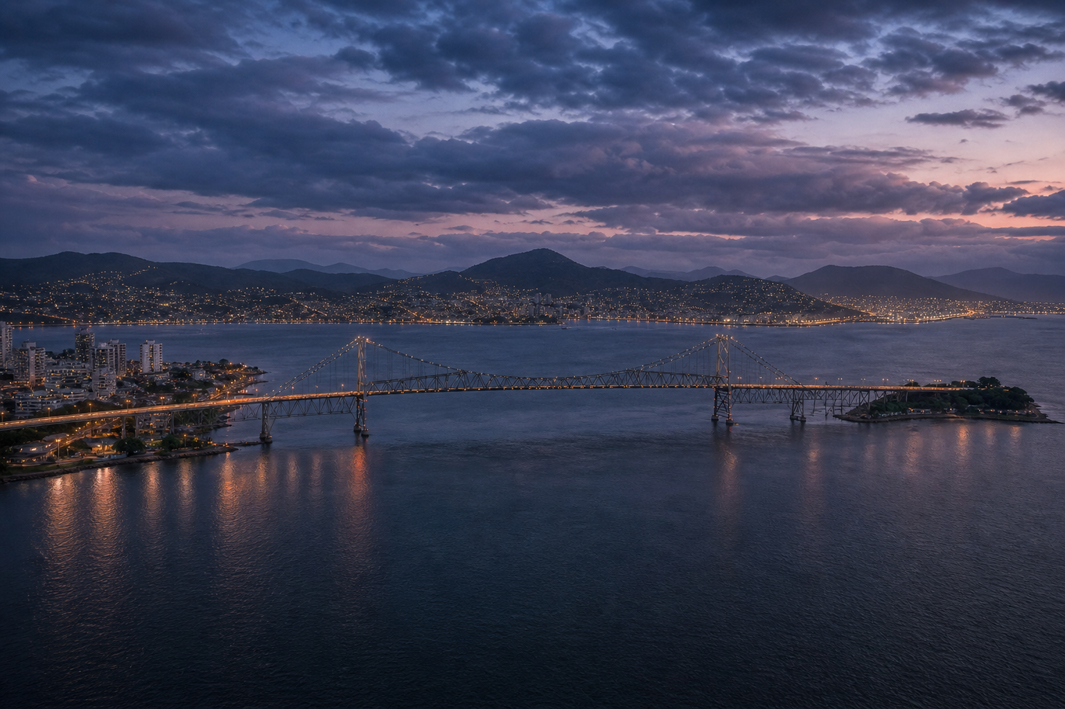 Vista da Ponte Hercílio Luz e da baía de Florianópolis ao anoitecer